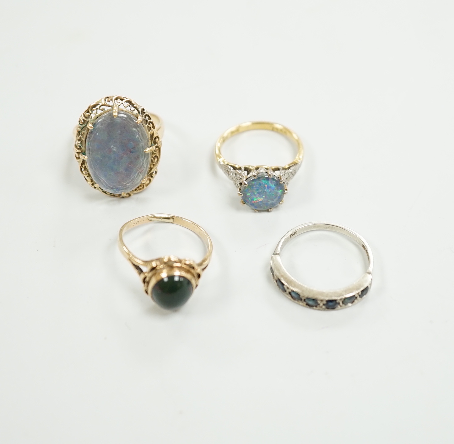 A 1940's 18ct and black opal doublet set dress ring, with diamond chip set shoulders, size L, a 14c and oval doublet ring and two other 9ct and gem set rings.
